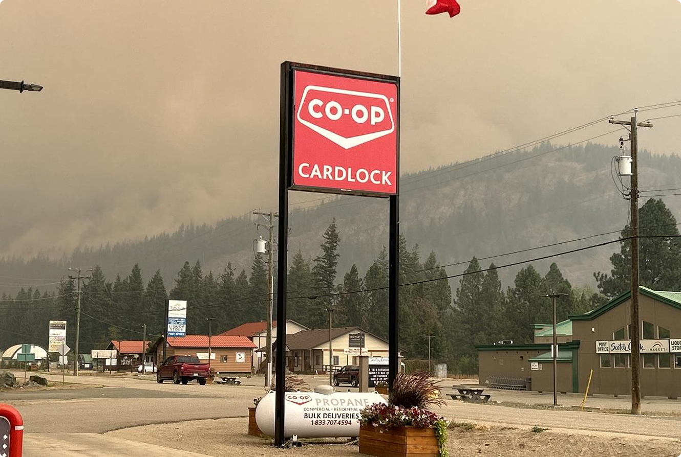 CO-OP Cardlock sign amid smoky wildfire sky